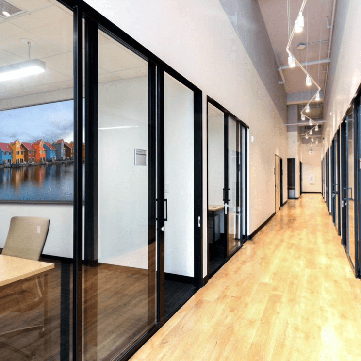 Metal frame clear glass sliding door divides meeting room from the lounge area