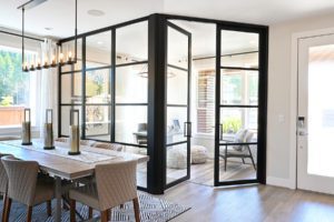 Living space with table and chairs glass room divider with swing doors