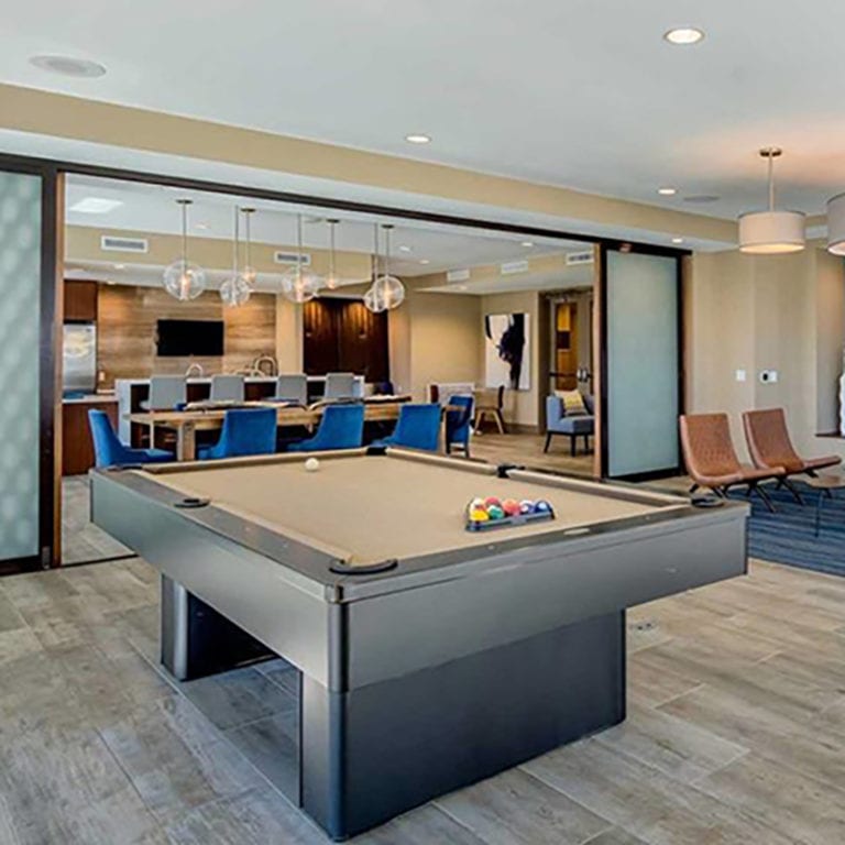 Pool table and kitchen area divided by frost glass fixed panels