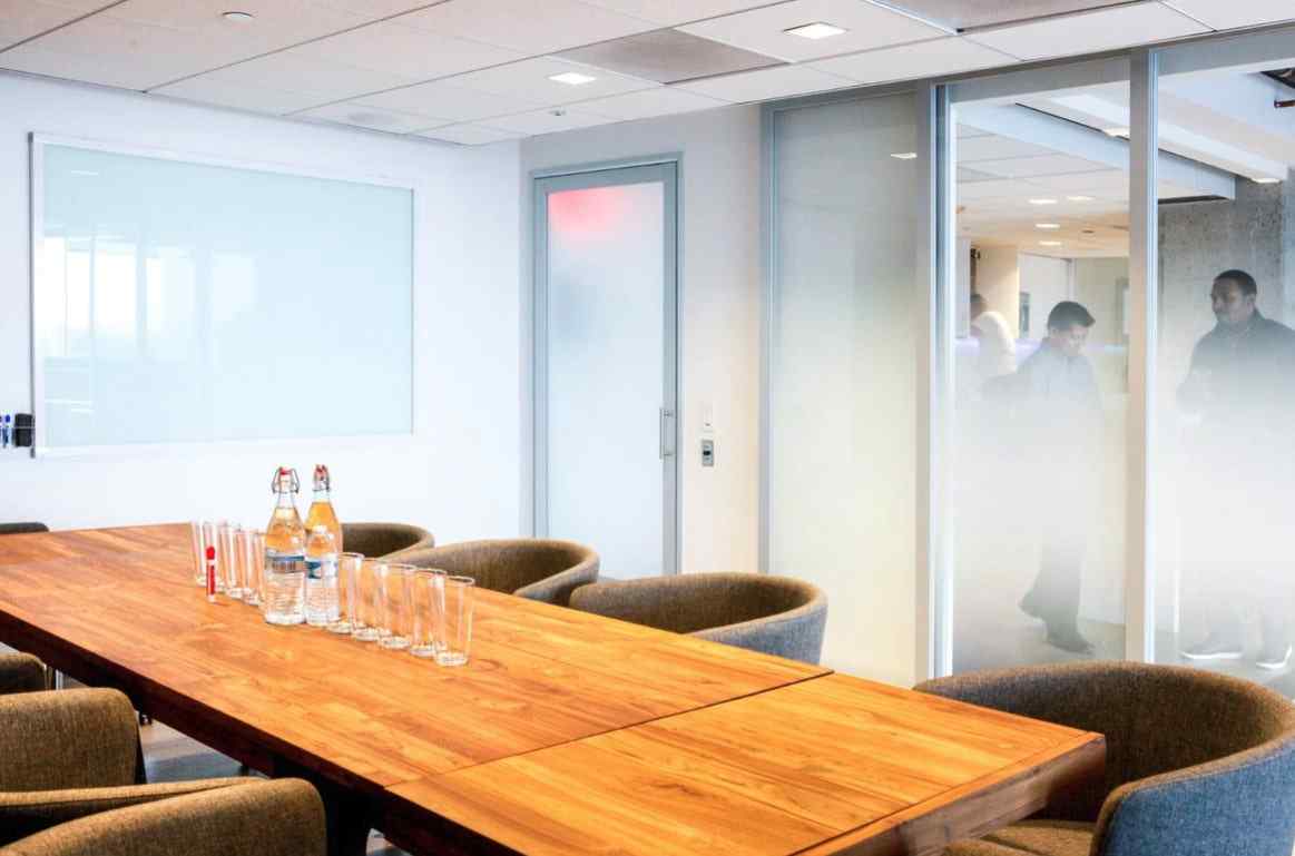 conference room with custom film suspended sliding glass doors and frosted swing door