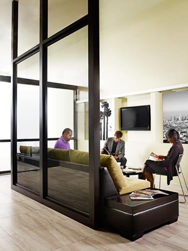 Modern office enviroment settings lounge style divided by metal framed fixed glass panels