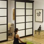 Girl meditating next to interior sliding frosted door